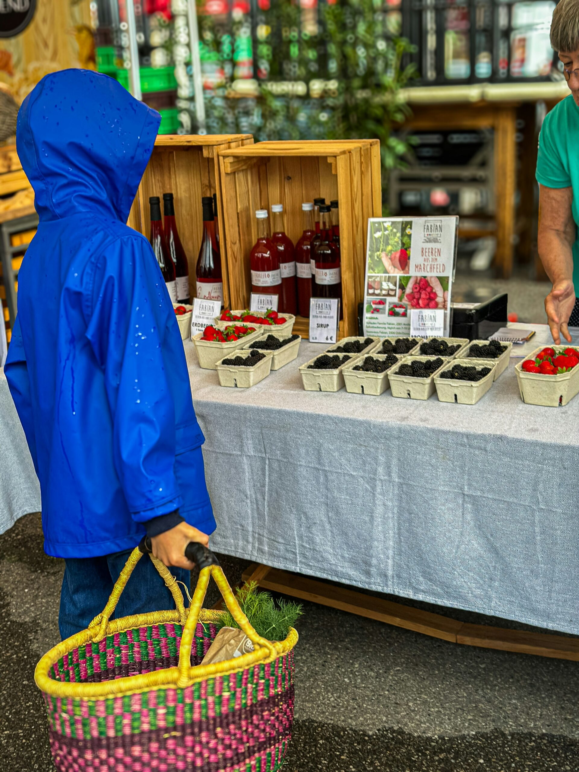 Two people standing at a table with a basket of food