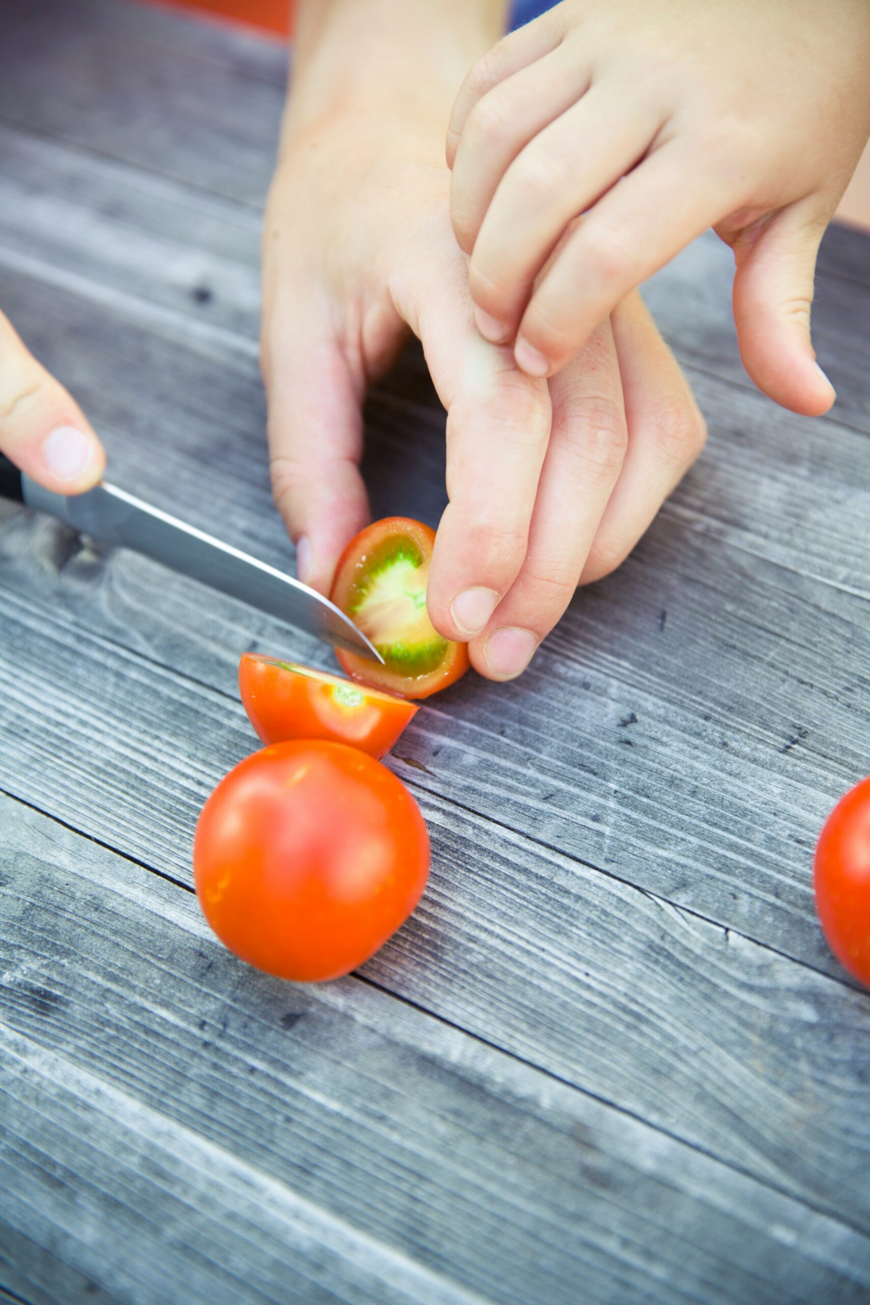 person slicing tomatoe